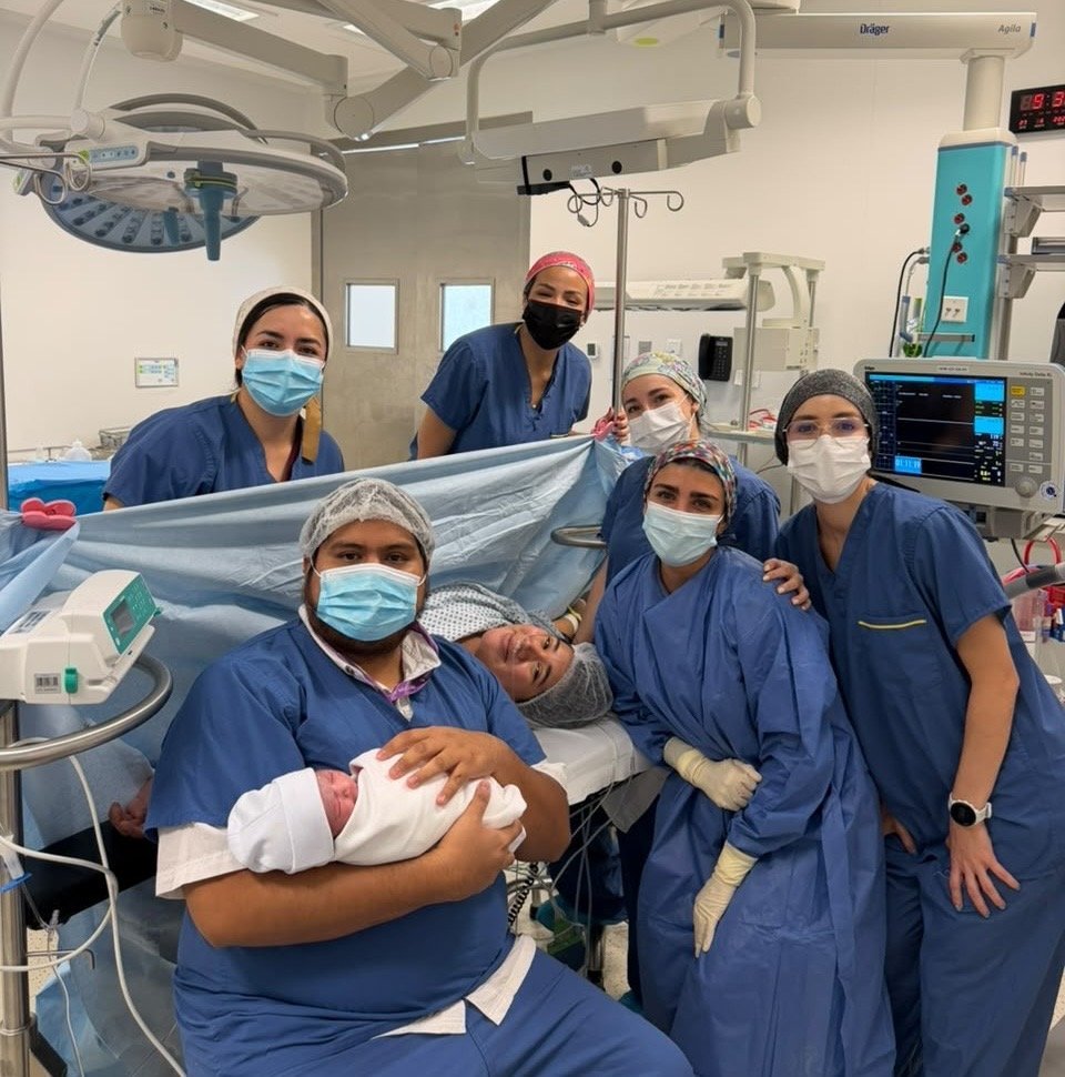 Todo el equipo médico junto a la mamá, el papá y el recién nacido