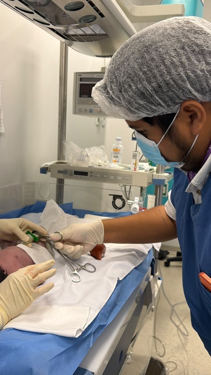 Papá cortando el cordón umbilical bajo la supervisión de la neonatóloga